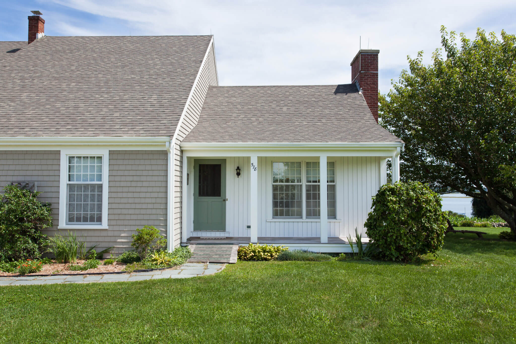 Natural Clay Cedar Impressions Vinyl Siding with White Vertical Vinyl Siding Installed on MA Home