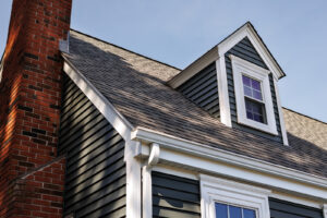 New asphalt shingle roof on a two-story family home with a brick chimney