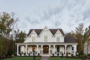 White house with a dark roof and expansive covered porch