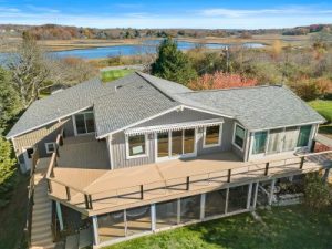 Aerial view of a gray house with a wraparound deck