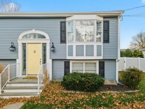 Light blue house with yellow door and white trim